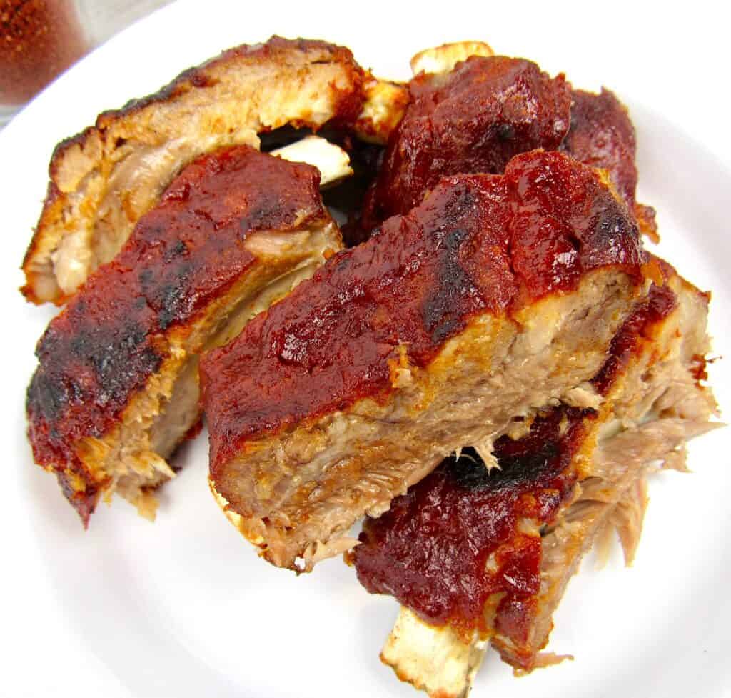 5 baby back ribs cut up on a white dish