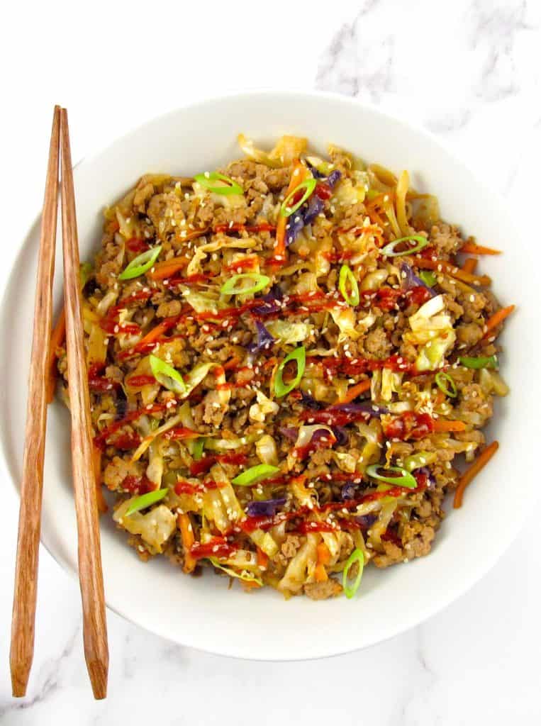 egg roll in a white bowl with chopsticks on side